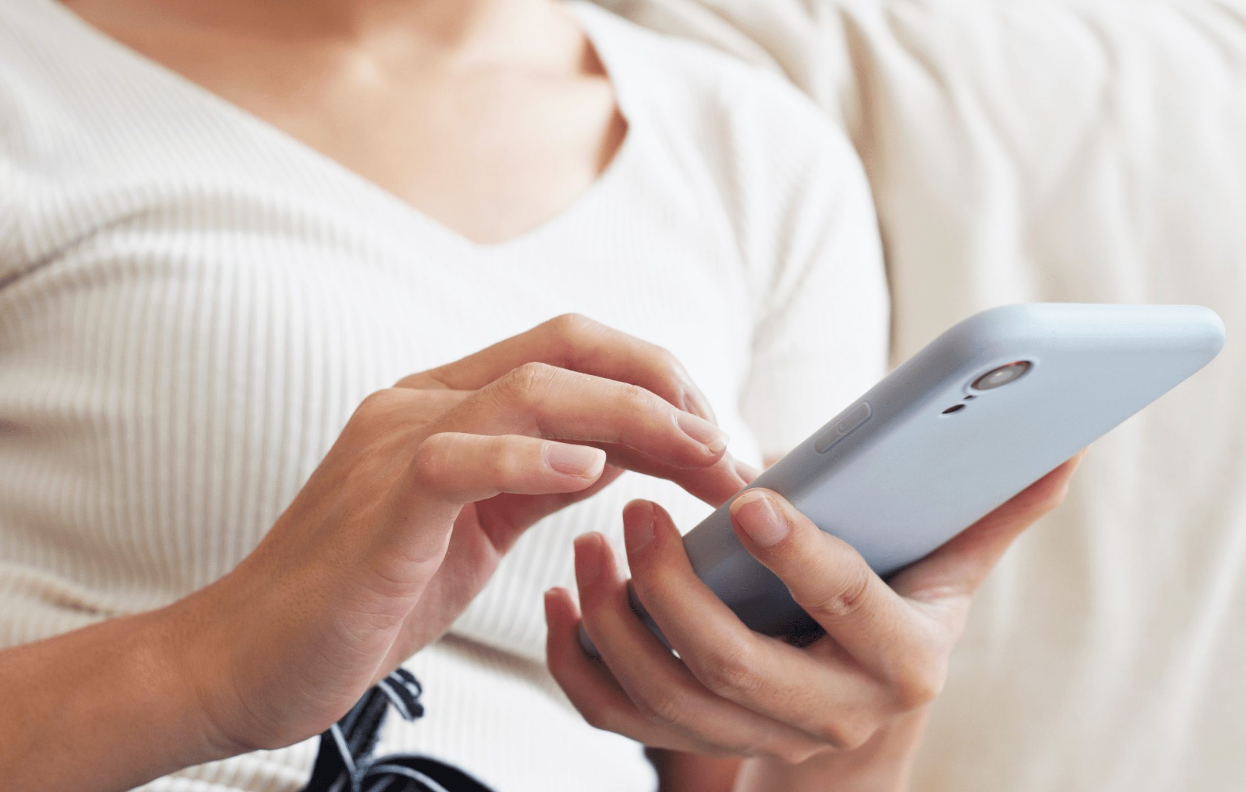 Mulher segurando smarthphone durante tratamento oncológico