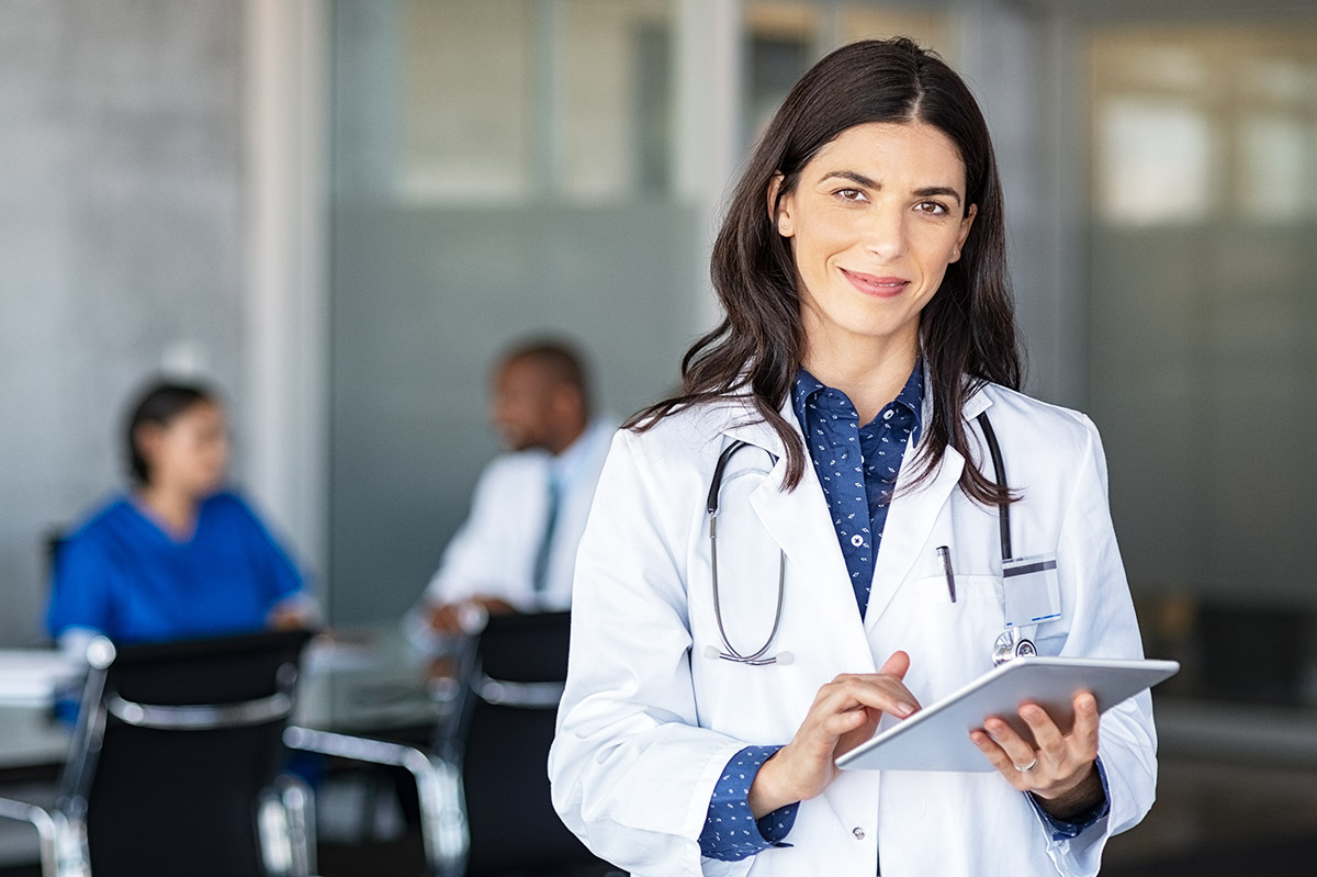 Médica feliz segurando tablet